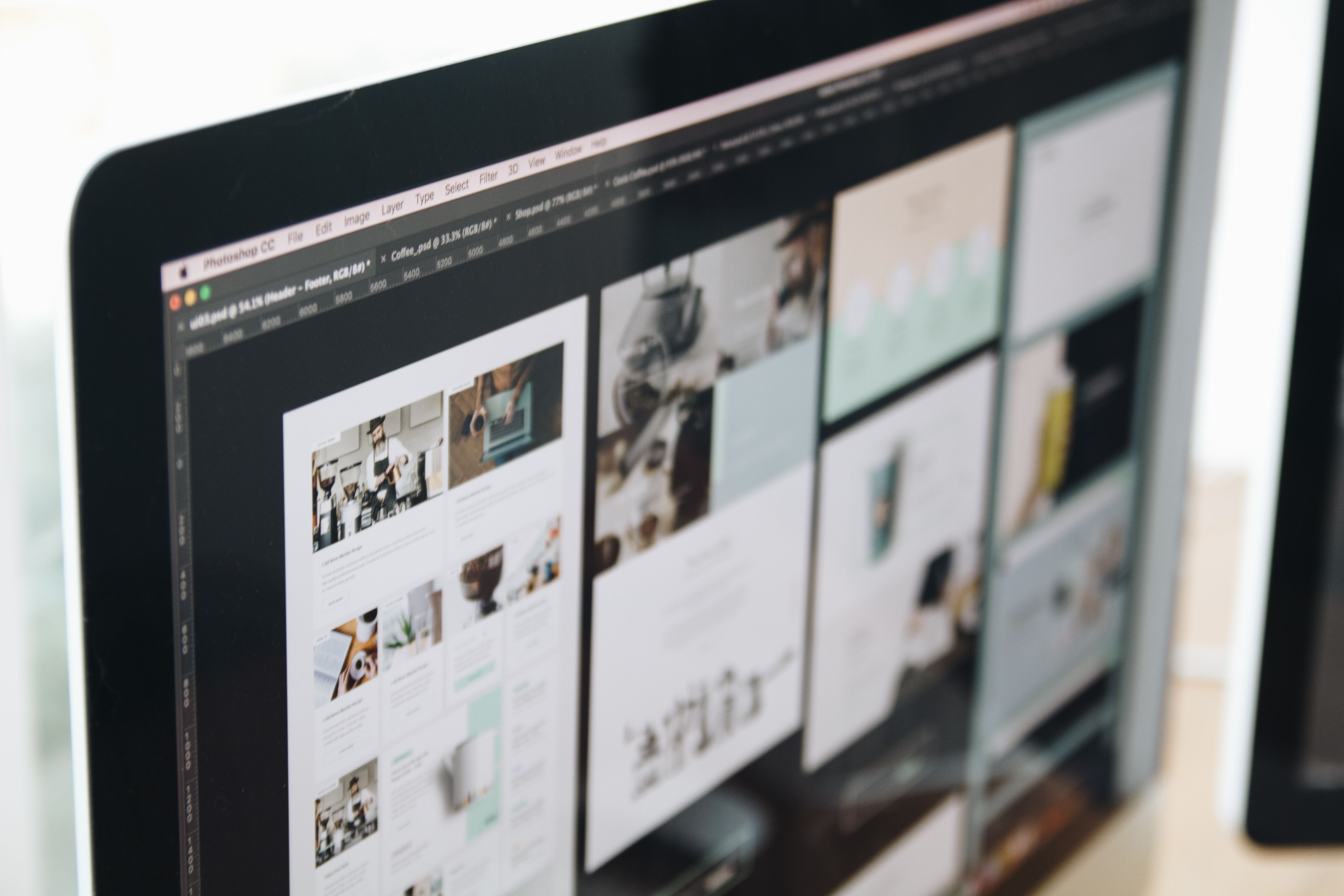 Dual monitors with blurred product dashboard and page wireframes on an empty desk