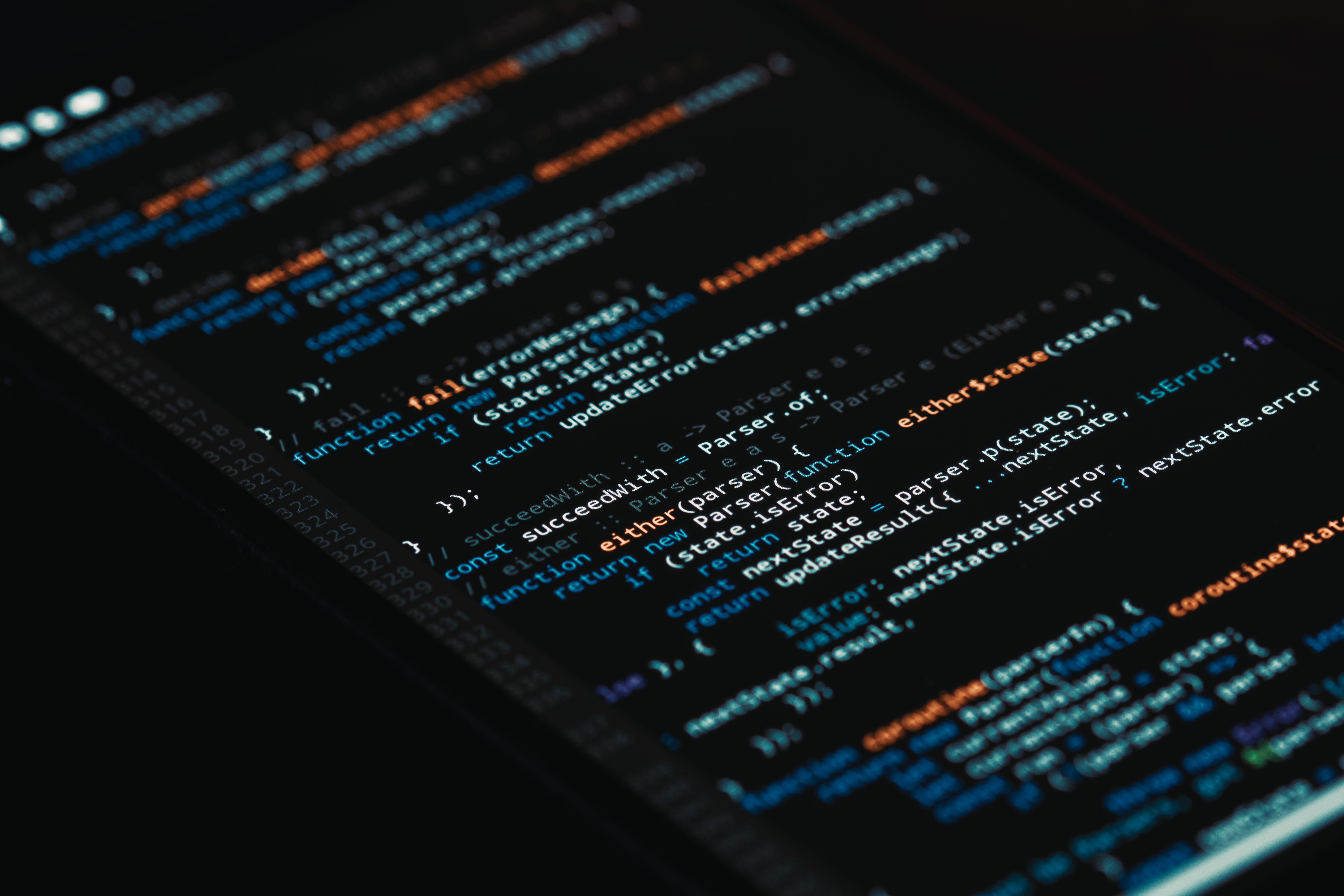 Smartphone displaying source code with a development environment in the background