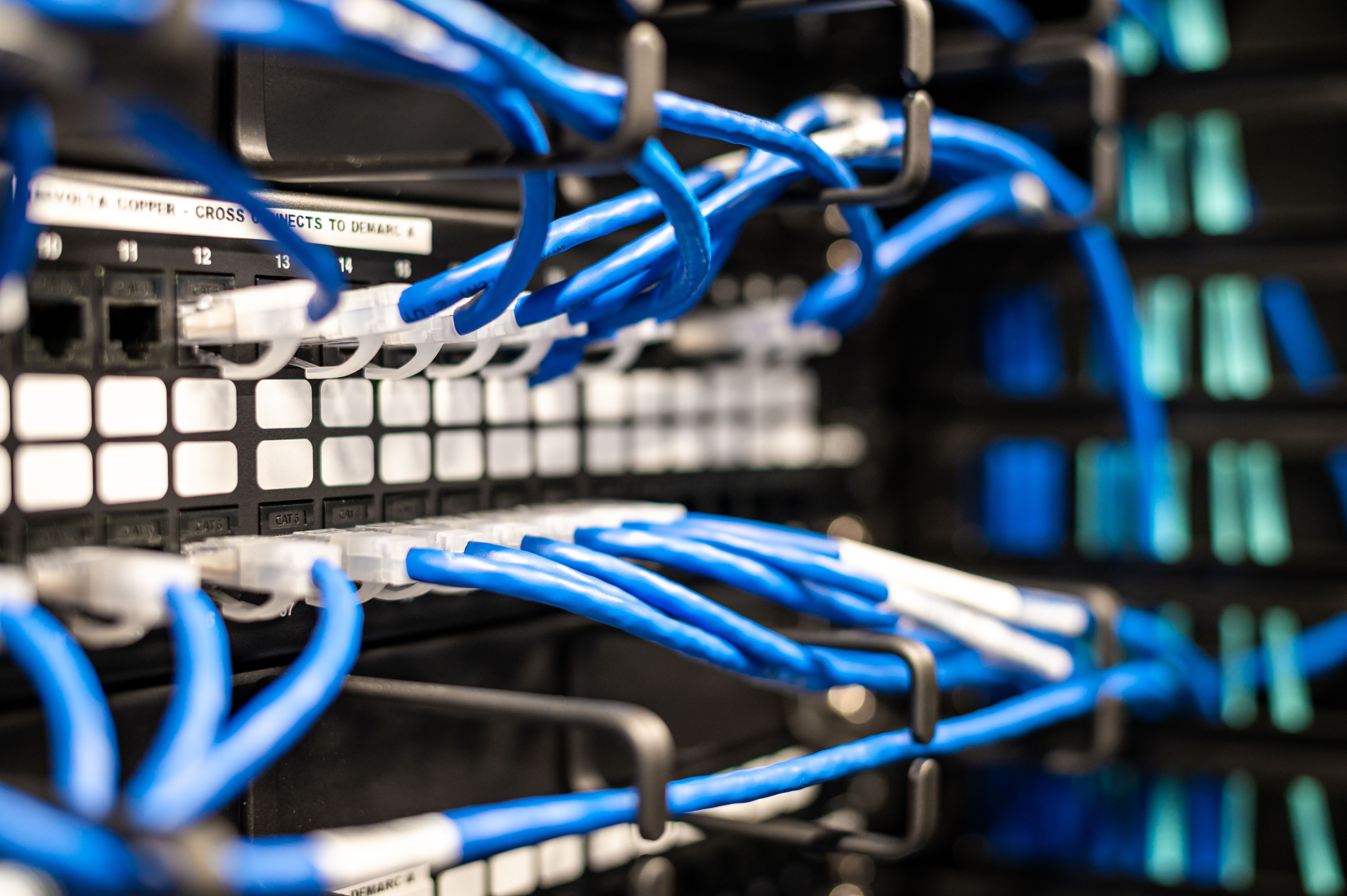 Close-up of network patch panel and fiber connections with indicator lights